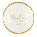 Round white plate with gold rim and text on a white background