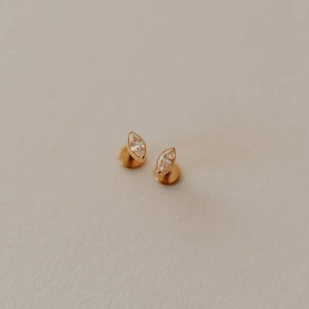 Pair of gold earrings on a light beige background