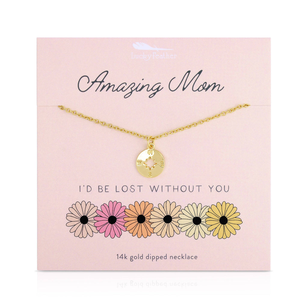 Gold necklace with a pendant on a pink card with floral designs and text.