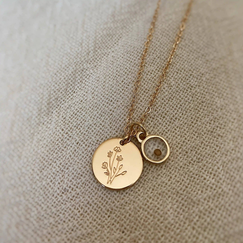 Gold necklace with round pendants on a beige fabric background