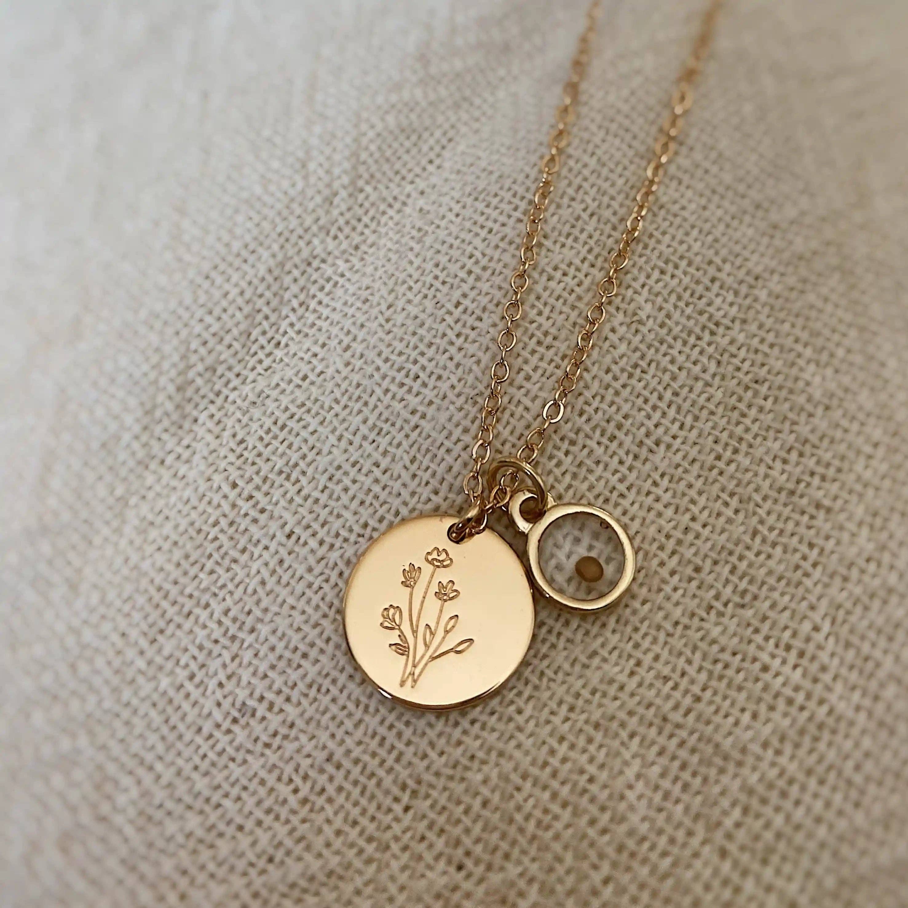 Gold necklace with round pendants on a beige fabric background