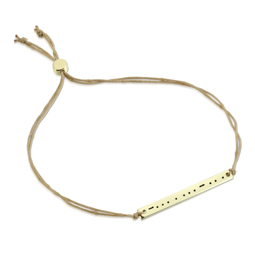 Gold bracelet with a bar charm on a white background