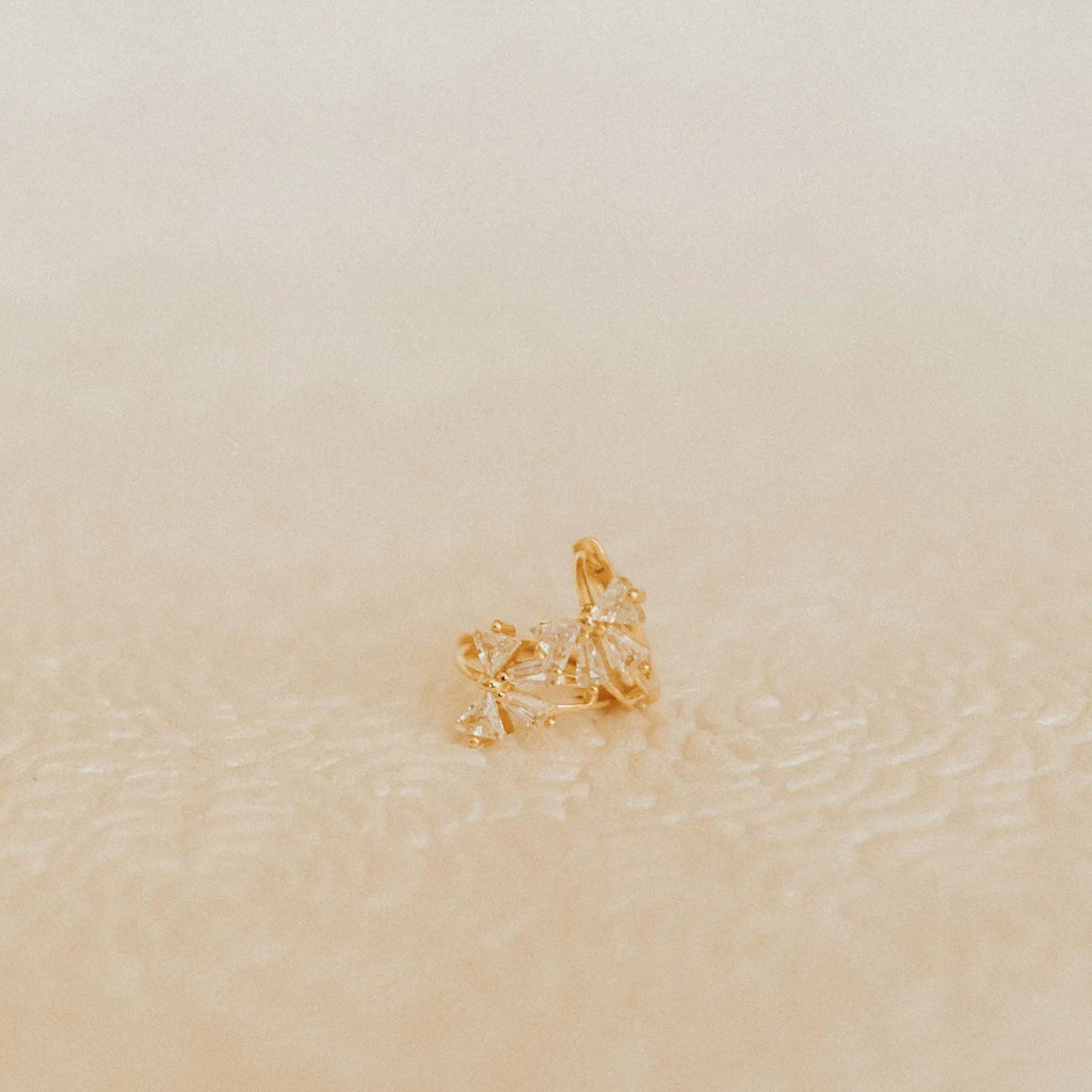 Gold ring with a star design on a beige background