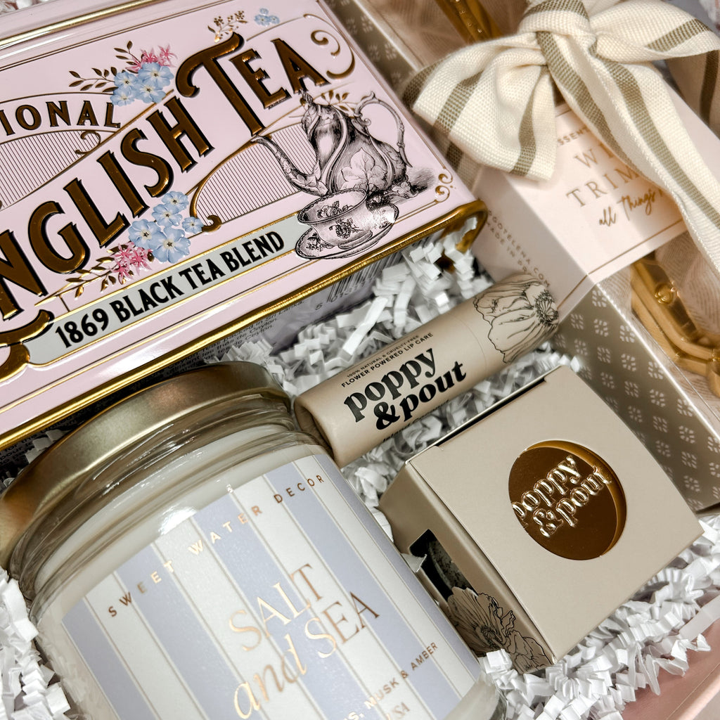 Gift set with a candle, tea box, and other items in a decorative box.