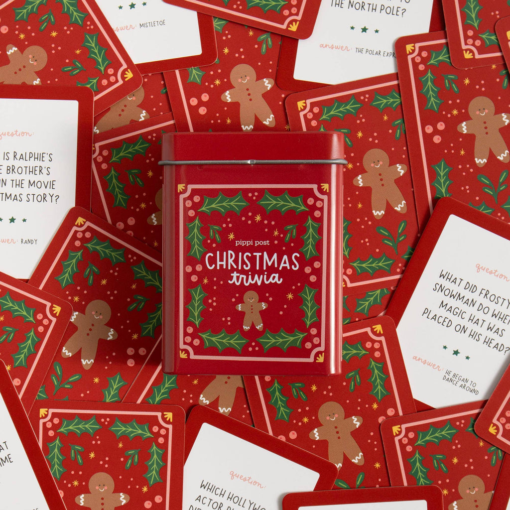 Red Christmas trivia game box surrounded by question cards with gingerbread men and holly design.