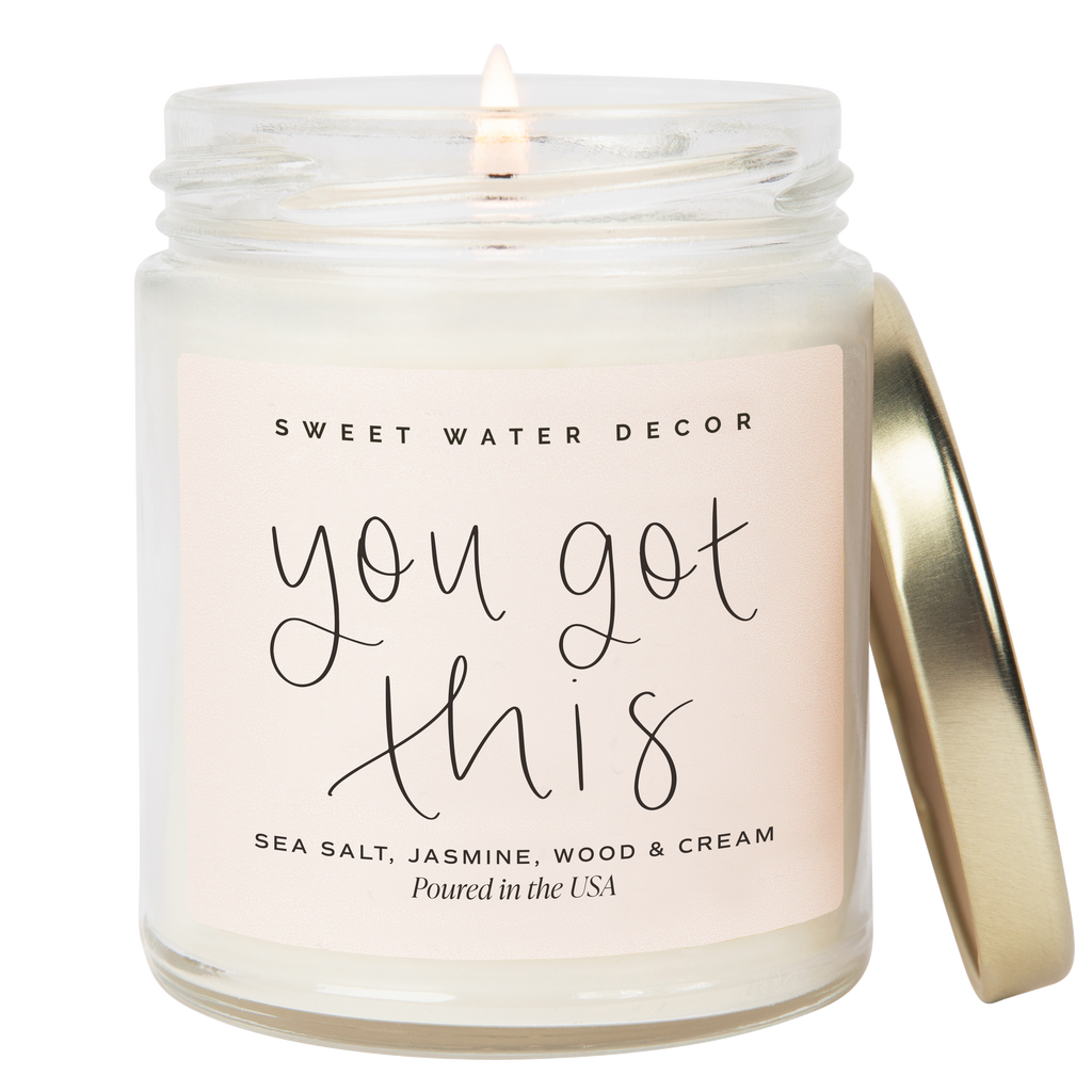 Candle in a glass jar with a gold lid, featuring a 'Sweet Water Decor' label.