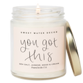 Candle in a glass jar with a gold lid, featuring a 'Sweet Water Decor' label.