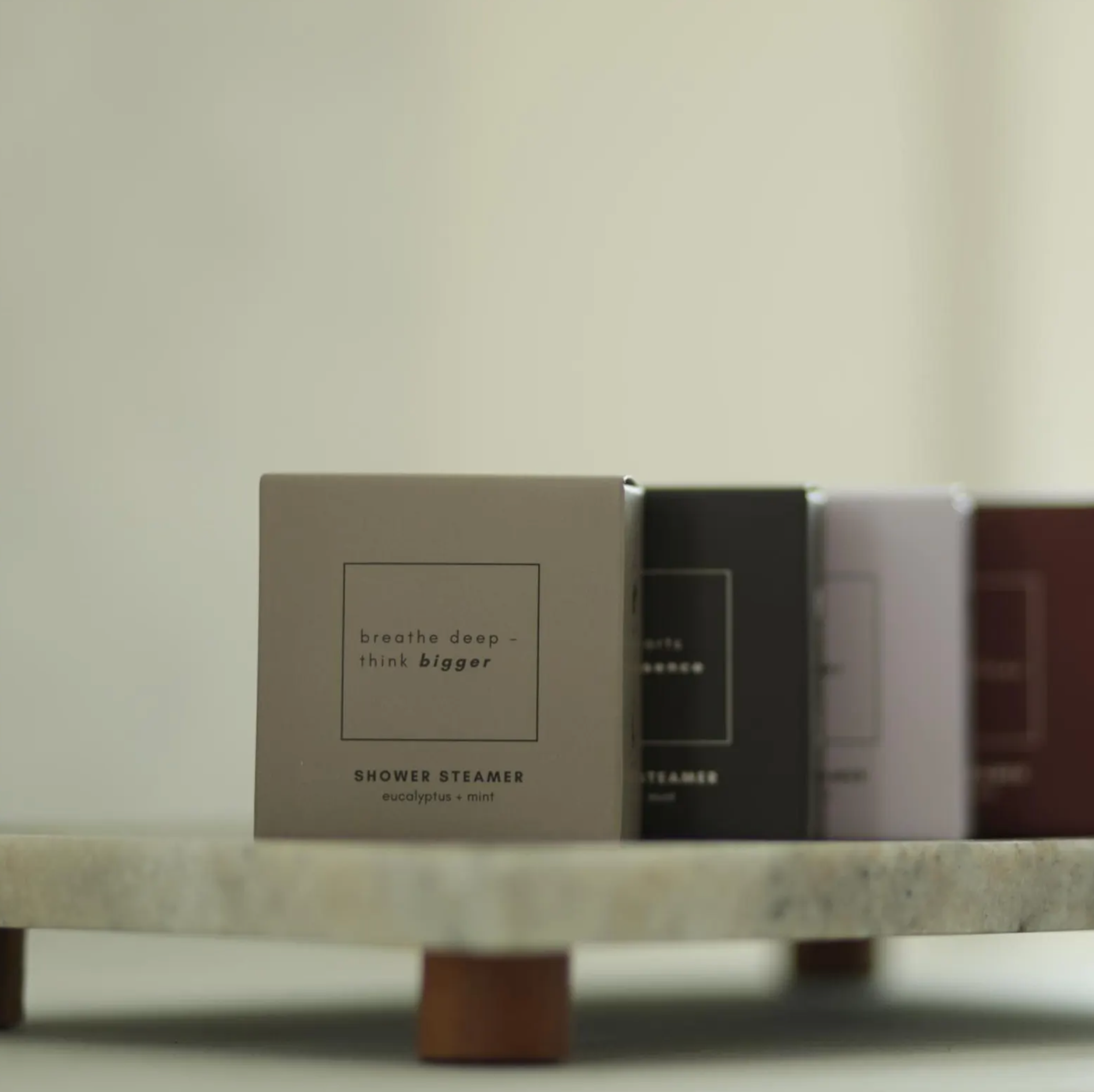 Row of shower steamers on a marble surface with a neutral background