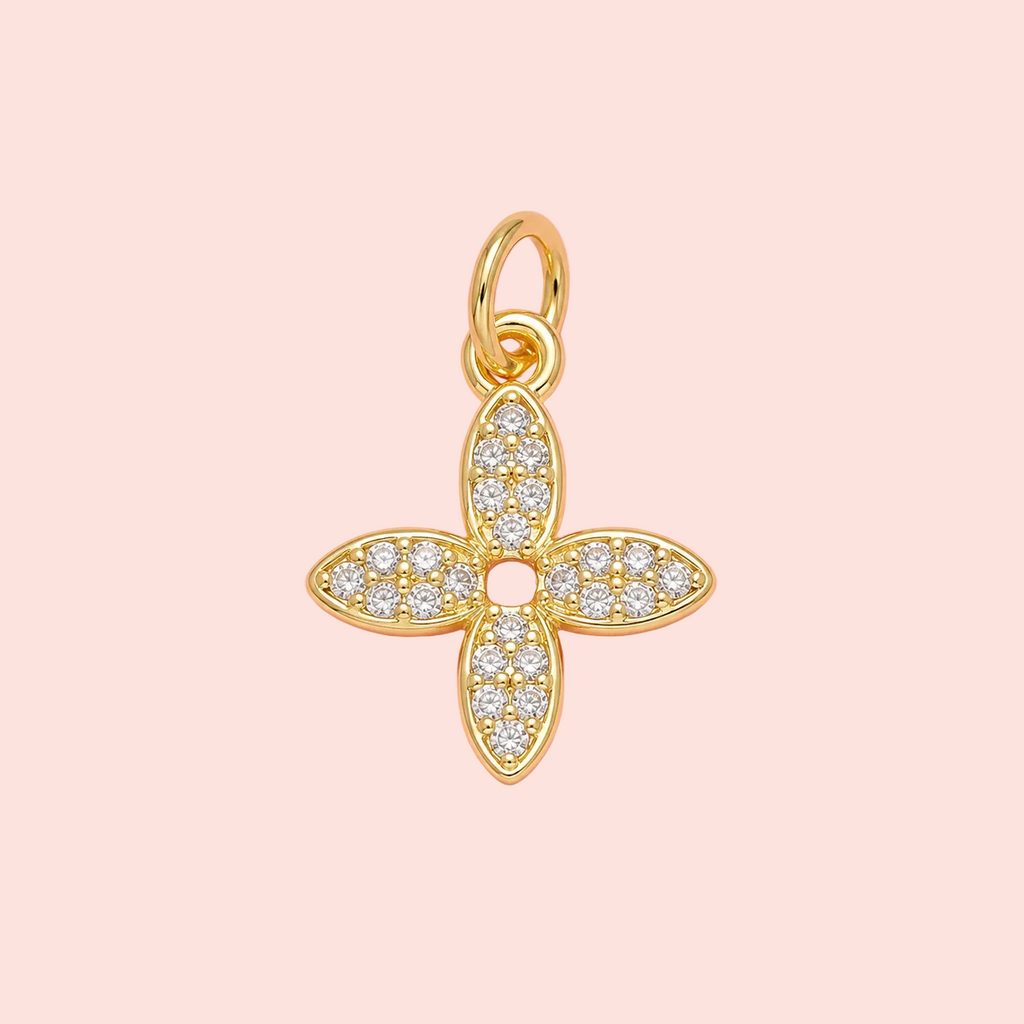 Gold and diamond pendant on a pink background