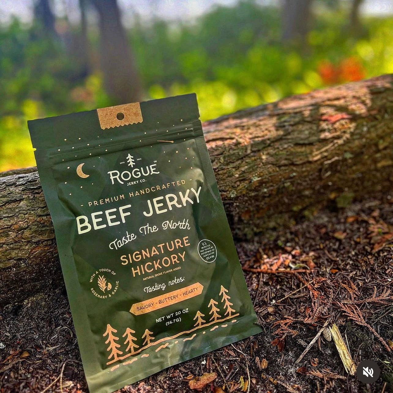 Packaged beef jerky on a log with a natural background