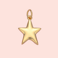 Gold star pendant on a pink background