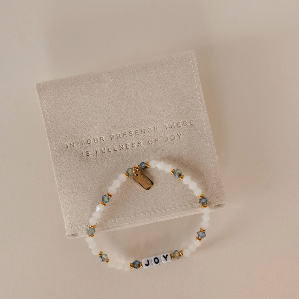 Bracelet with 'JOY' beads on a beige card with text
