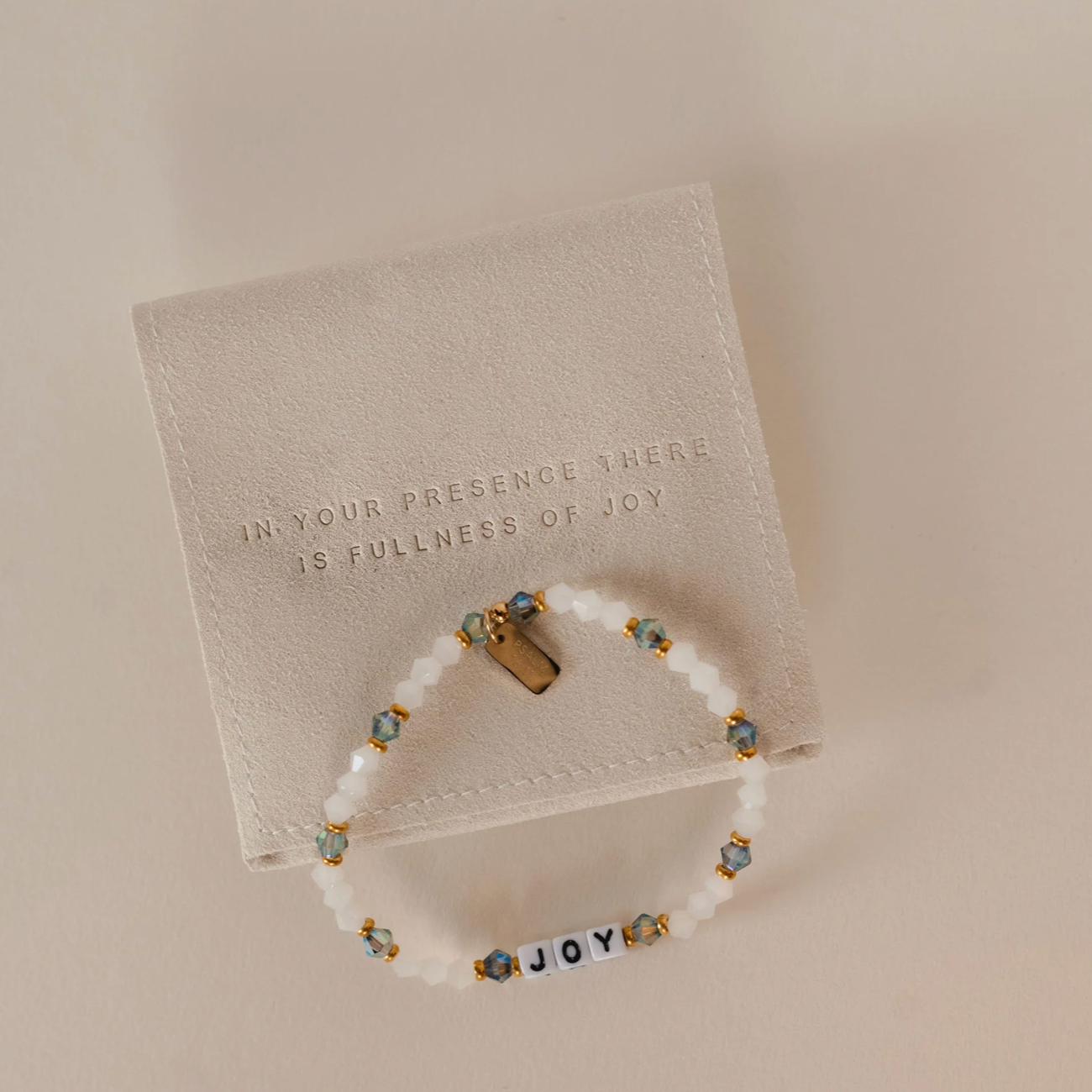 Bracelet with 'JOY' beads on a beige card with text
