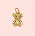 Gold teddy bear charm on a pink background