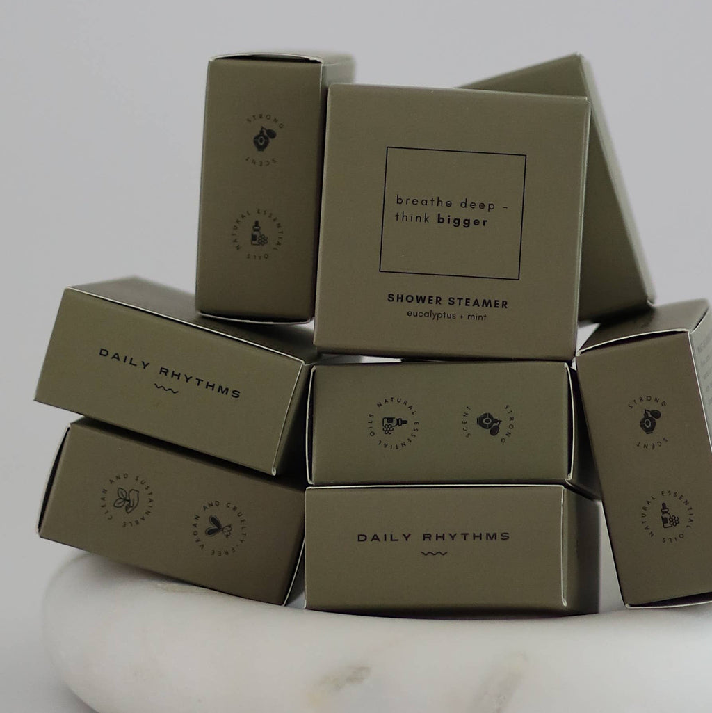 Stack of brown boxes with 'Daily Rhythms' branding on a white marble surface.