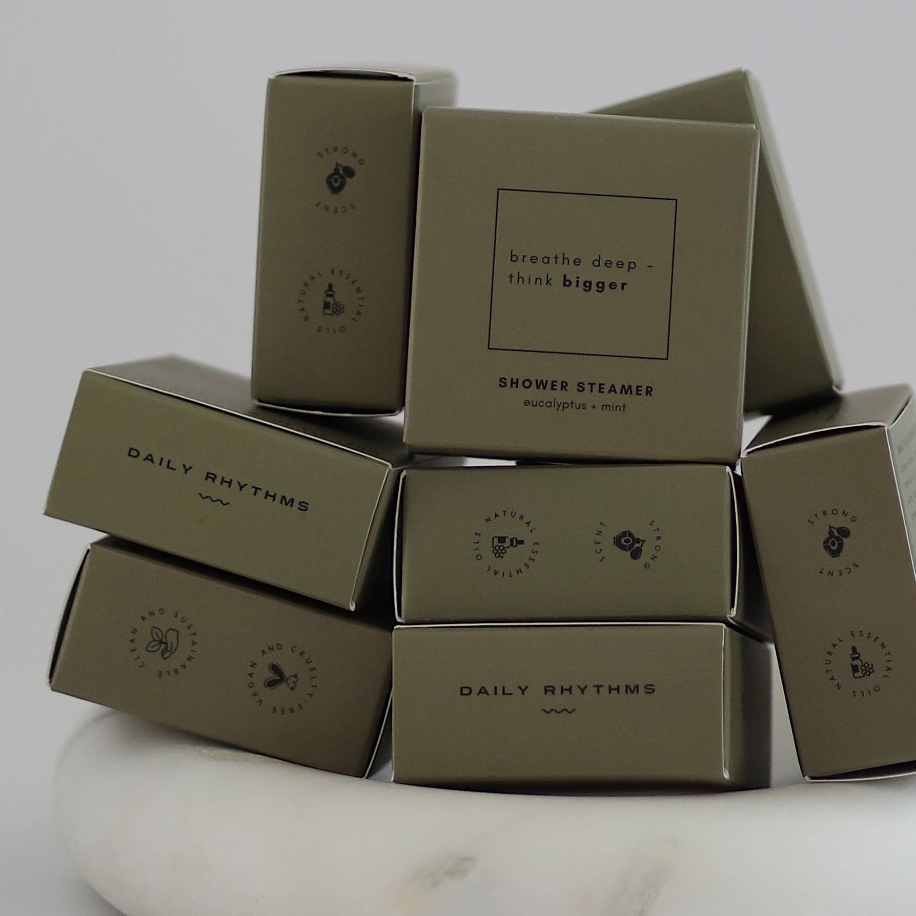 Stack of brown boxes with 'Daily Rhythms' branding on a white marble surface.