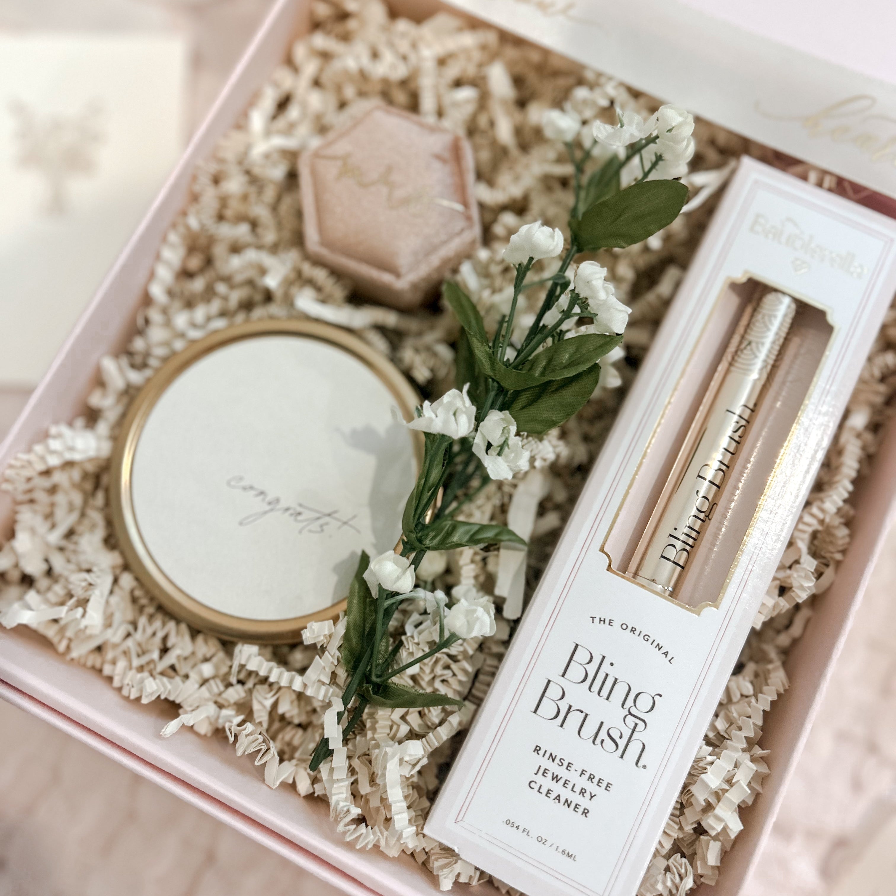 Cosmetic set with mirror, brush, and packaging in a decorative box.