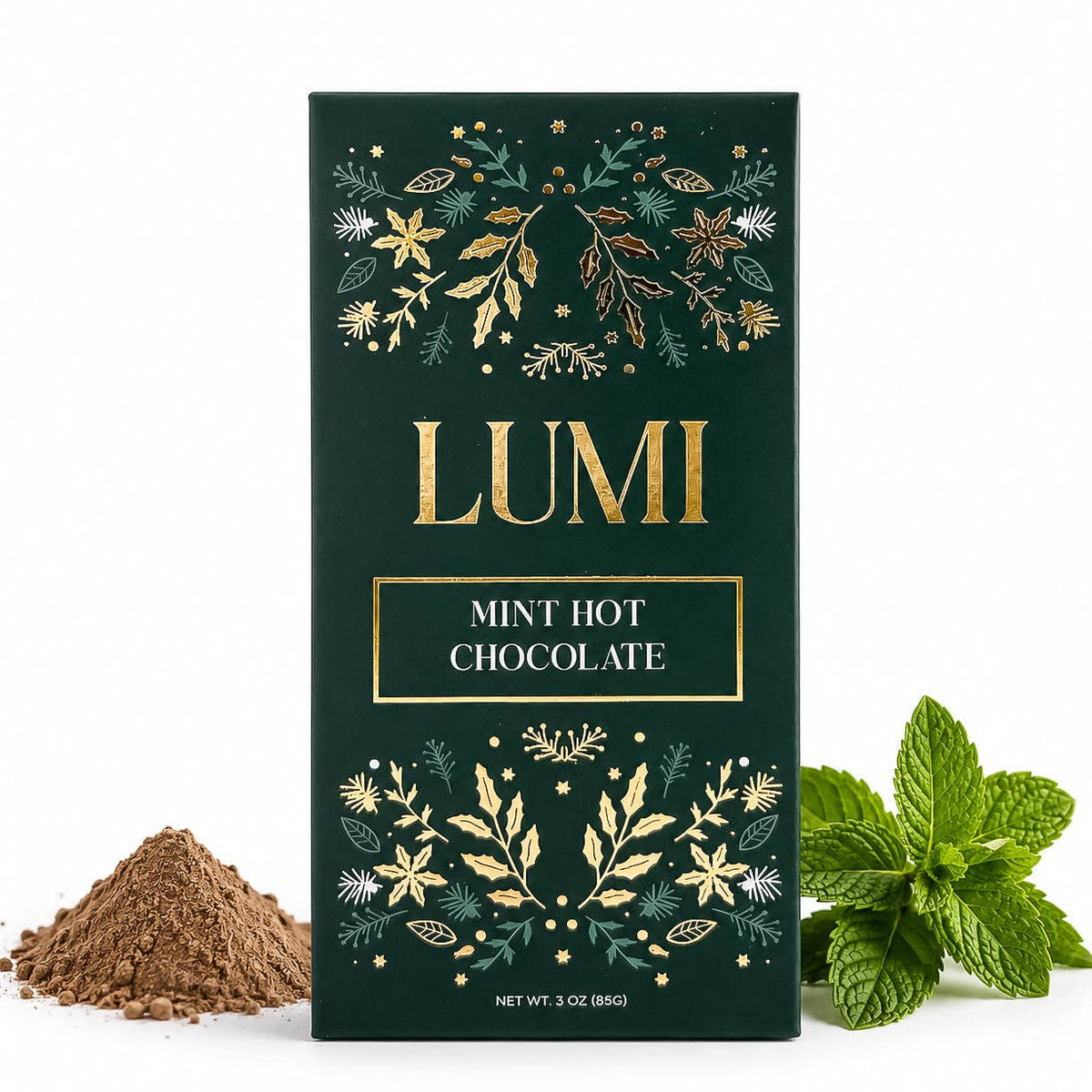 A dark green box of LUMI Mint Hot Chocolate with gold foil botanical illustrations, displayed on a white background with a small pile of chocolate powder on the left and fresh mint leaves on the right.