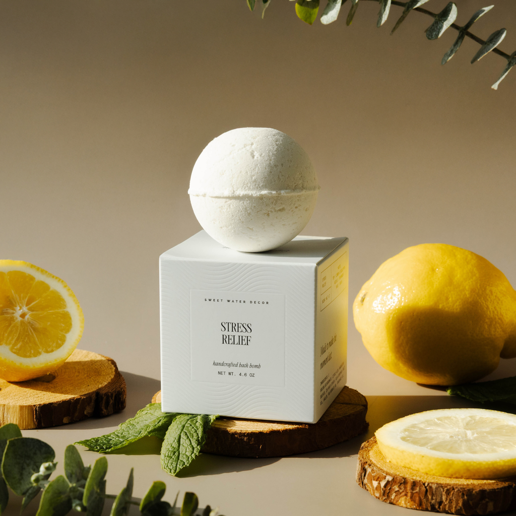 Bath bomb on a box labeled 'Stress Relief' with lemons and greenery on a neutral background