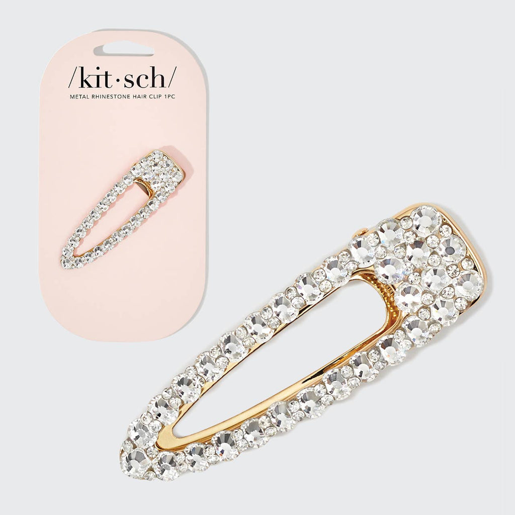 Gold and crystal hair clip with packaging on a light gray background