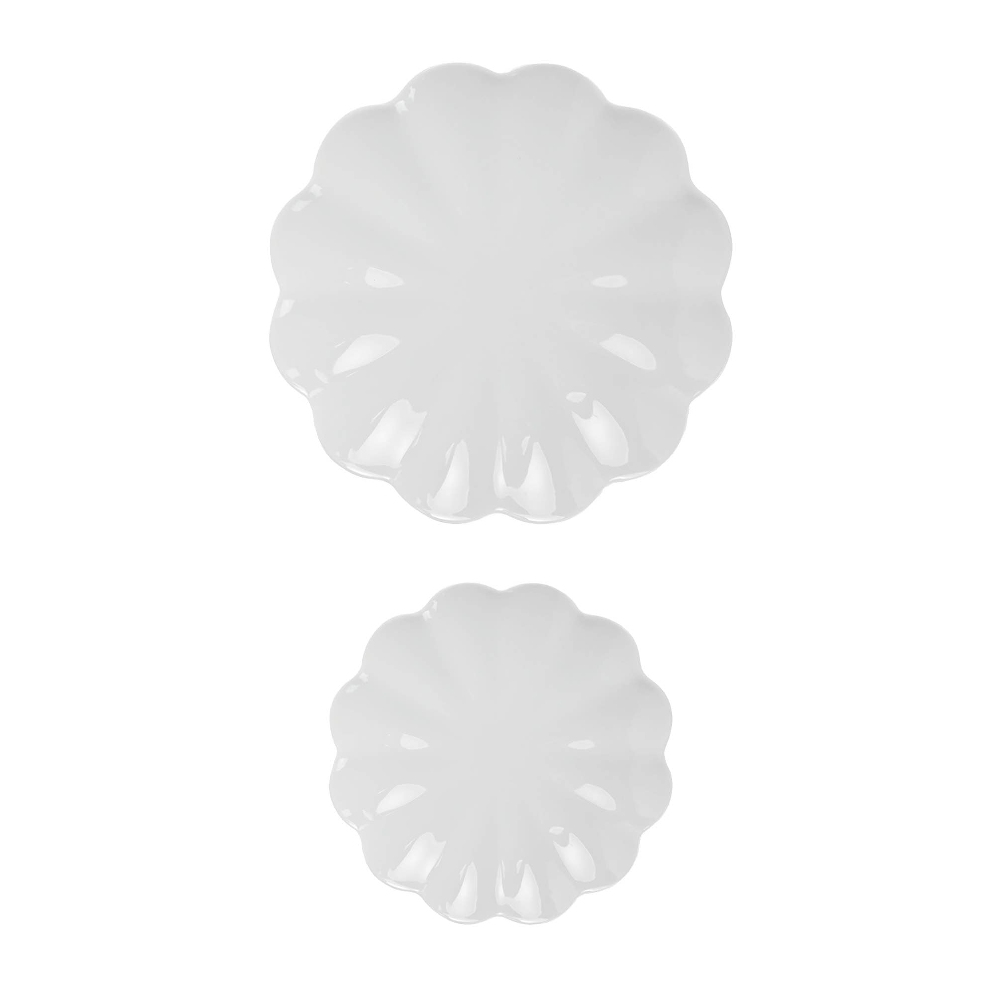 Two white decorative items with scalloped edges on a white background