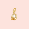 Gold pendant with a clear gemstone on a pink background
