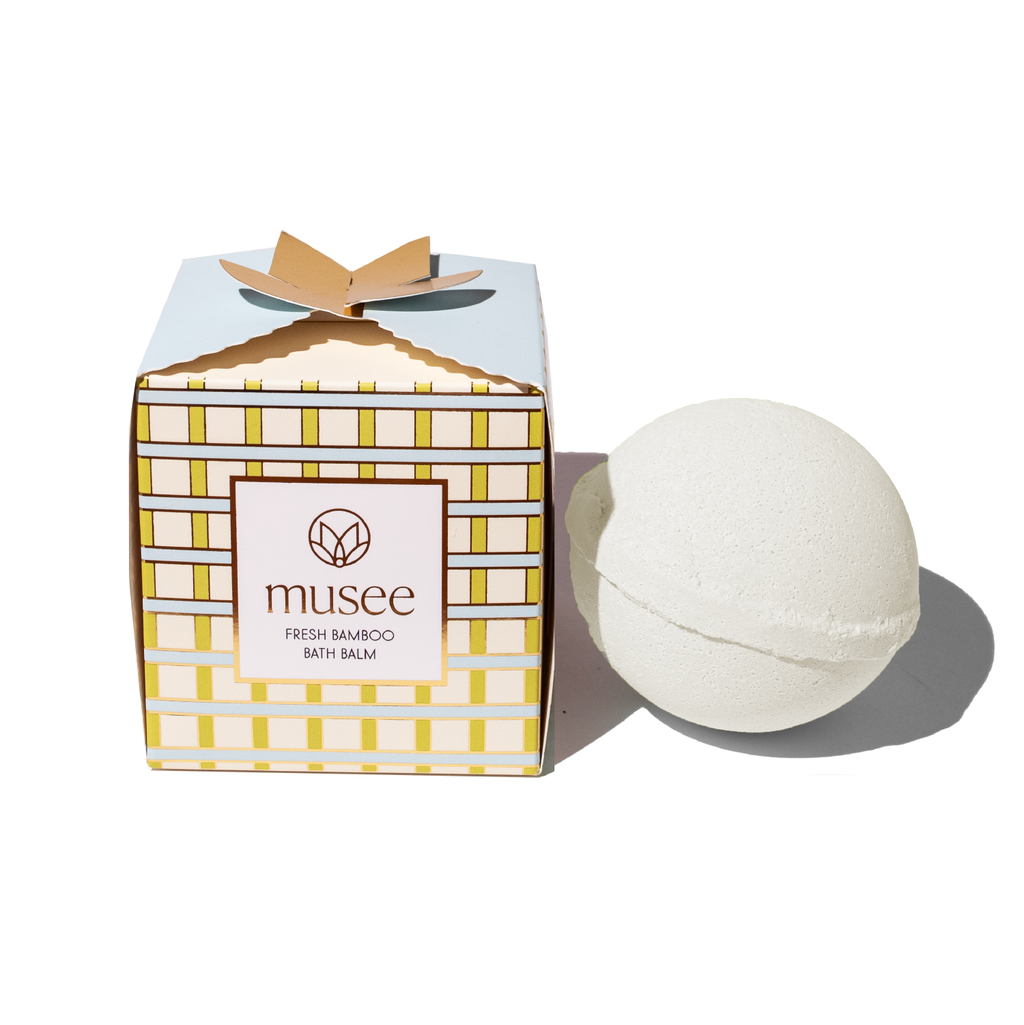 Bath balm next to its packaging with 'musee' branding on a white background