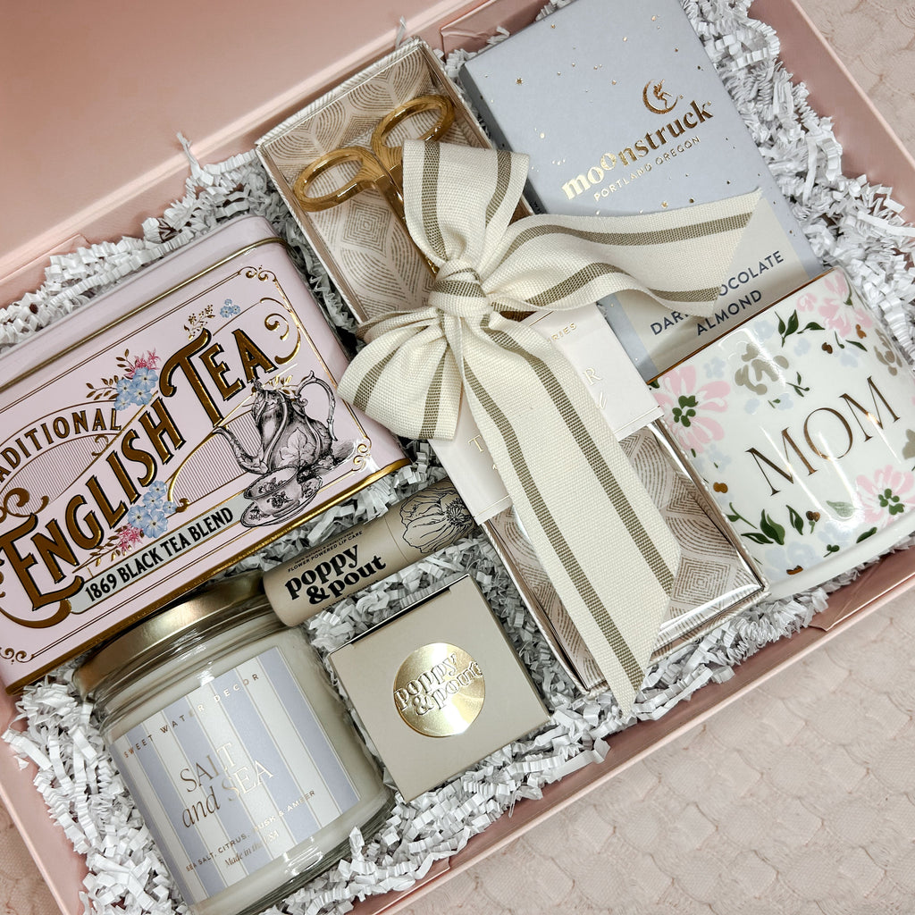 Gift set with tea, cookies, and a candle in a decorative box.