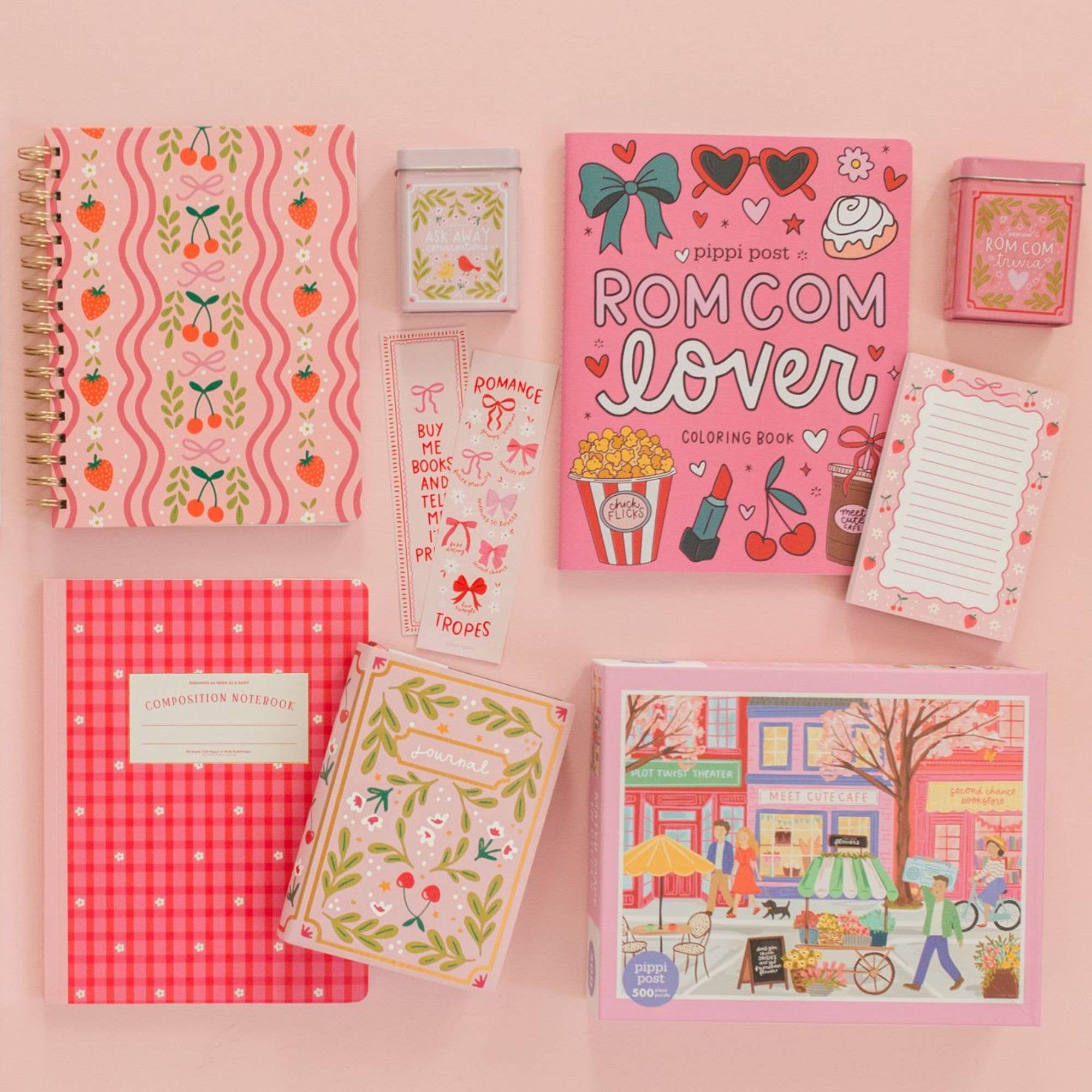 Collection of stationery items including notebooks and a coloring book on a pink background