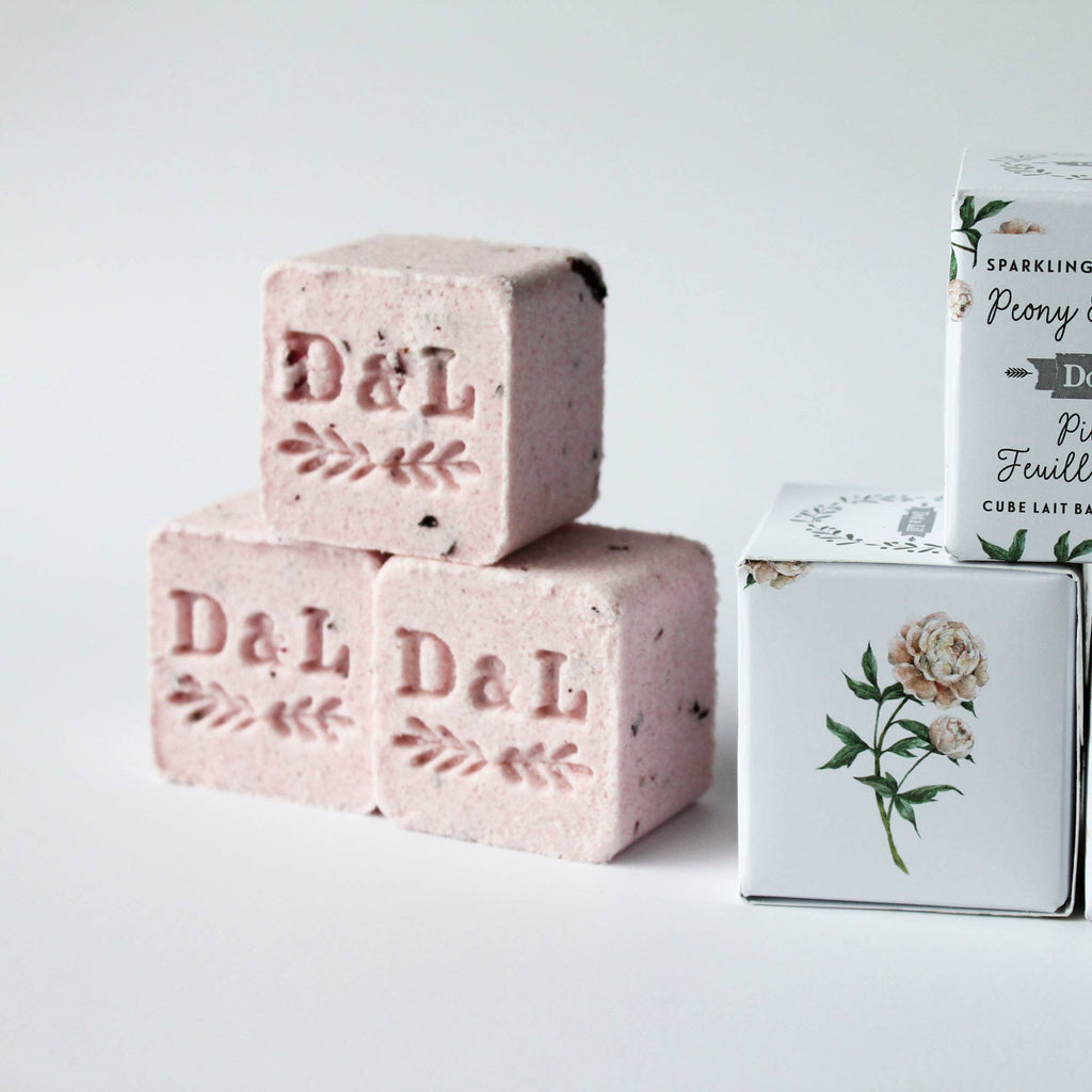 Pink soap bars and boxes with branding on a light gray background