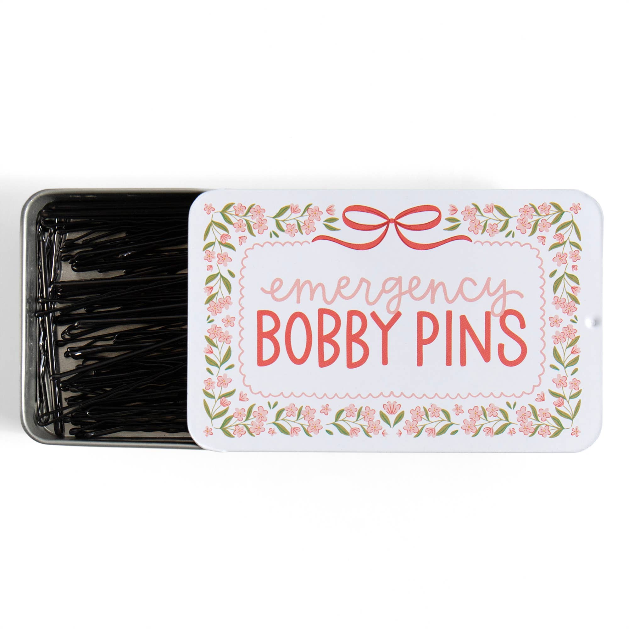 Tin of emergency bobby pins with decorative label on a white background