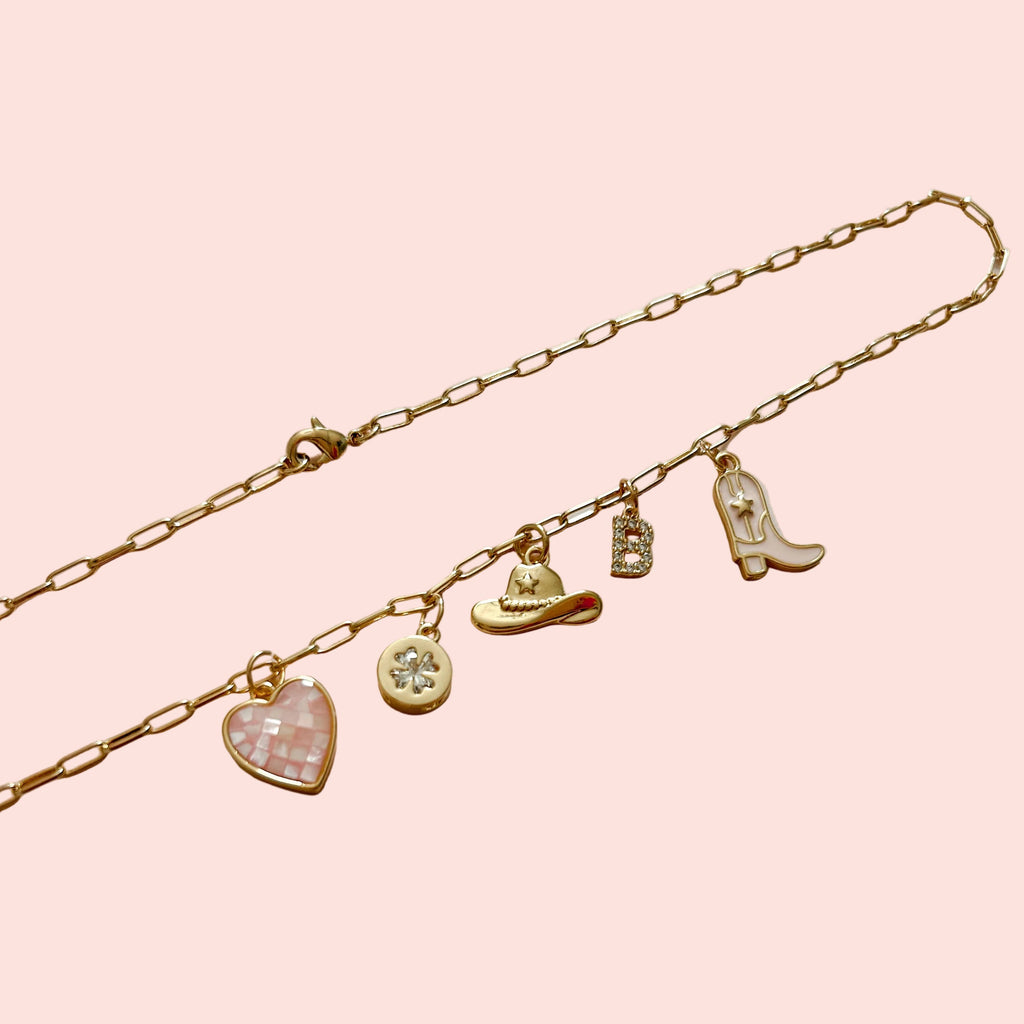 Gold bracelet with various charms on a light background