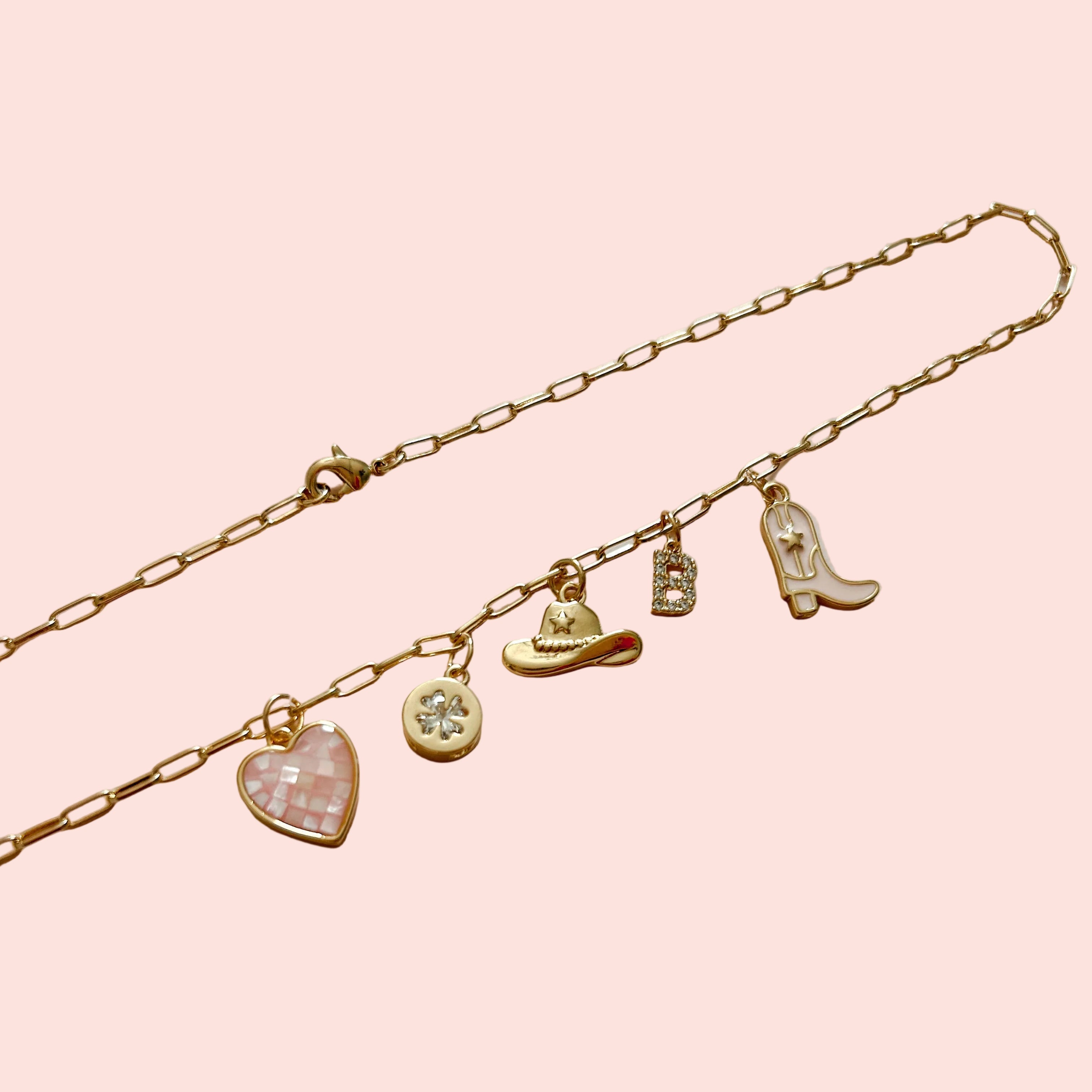 Gold bracelet with various charms on a light background