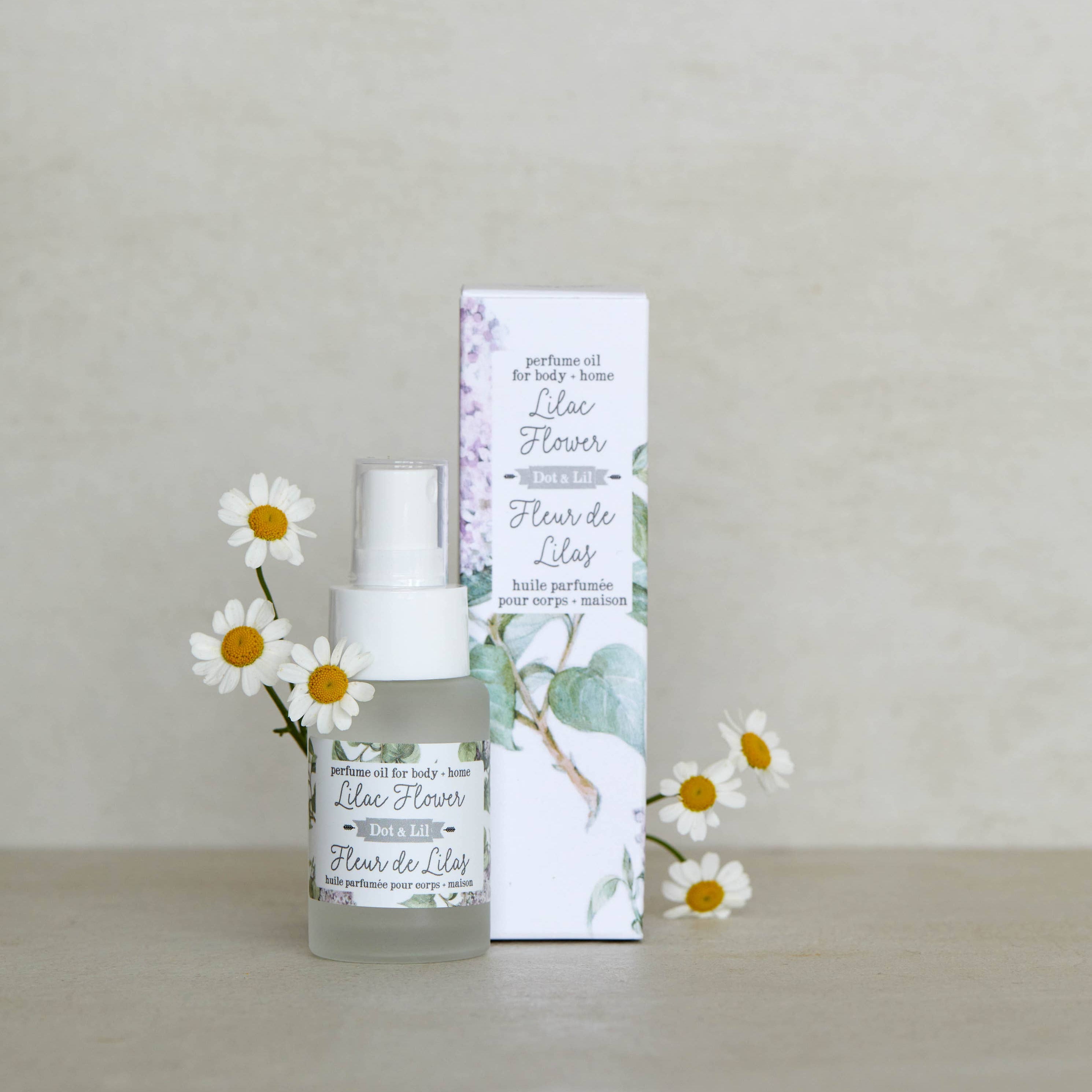 Floral perfume bottle with packaging and flowers on a neutral background