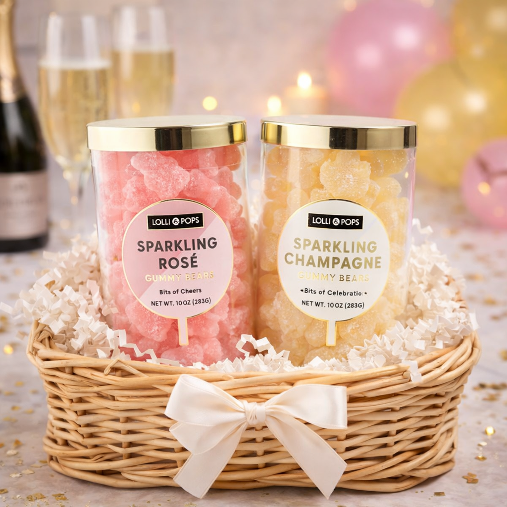 Two jars of Lollipops Sparkling Rose and Sparkling Champagne in a decorative basket with balloons and champagne in the background.