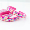 Pink headbands with colorful sequin flowers on a white background