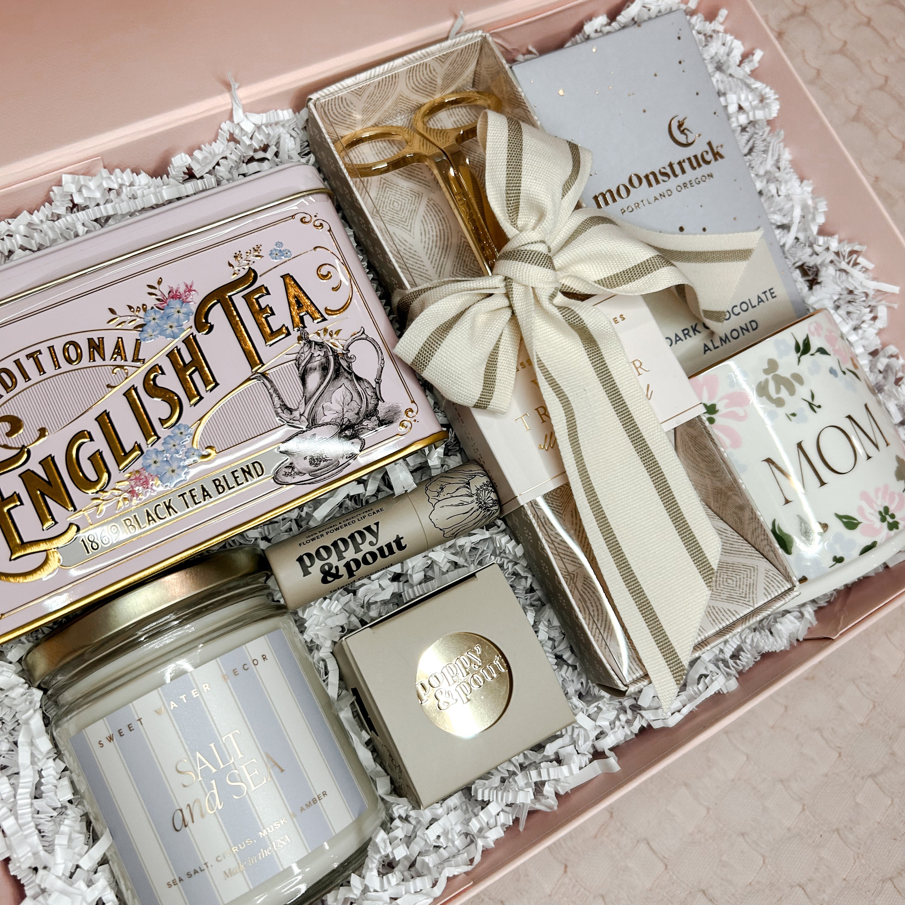 Gift set with tea, candle, and other items in a decorative box.