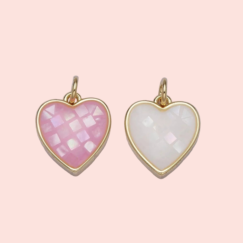 Two heart-shaped pendants with gold frames on a light gray background