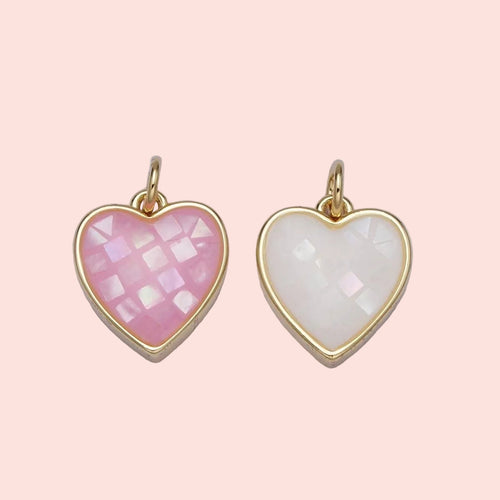 Two heart-shaped pendants with gold frames on a light gray background