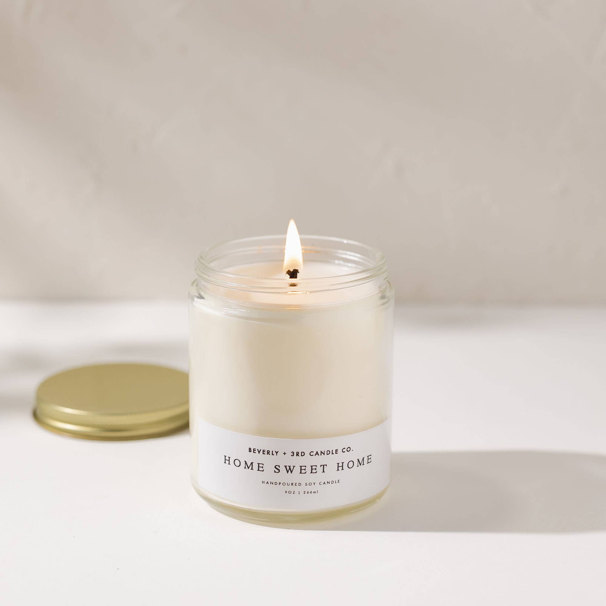 Candle with 'Home Sweet Home' label on a neutral background