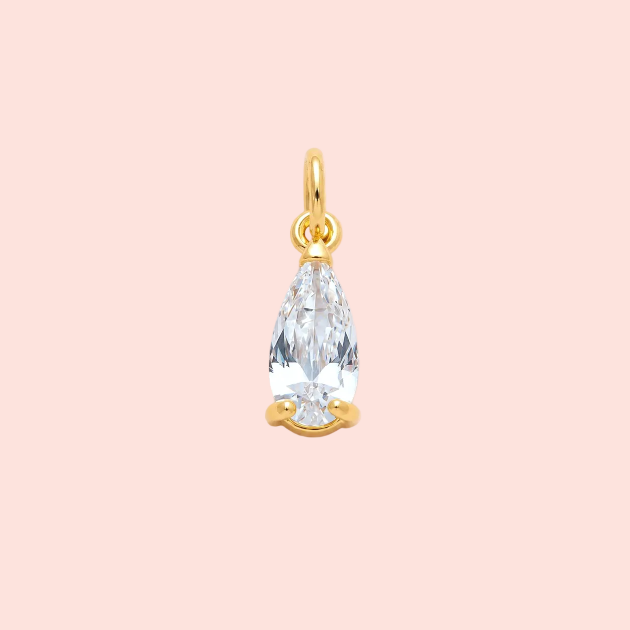 Gold pendant with a clear teardrop-shaped gemstone on a pink background