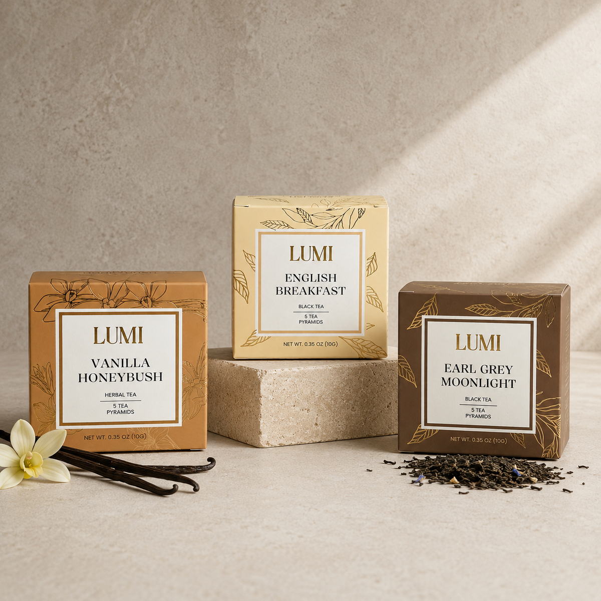 Three LUMI tea packages on a neutral background with vanilla beans and a flower.