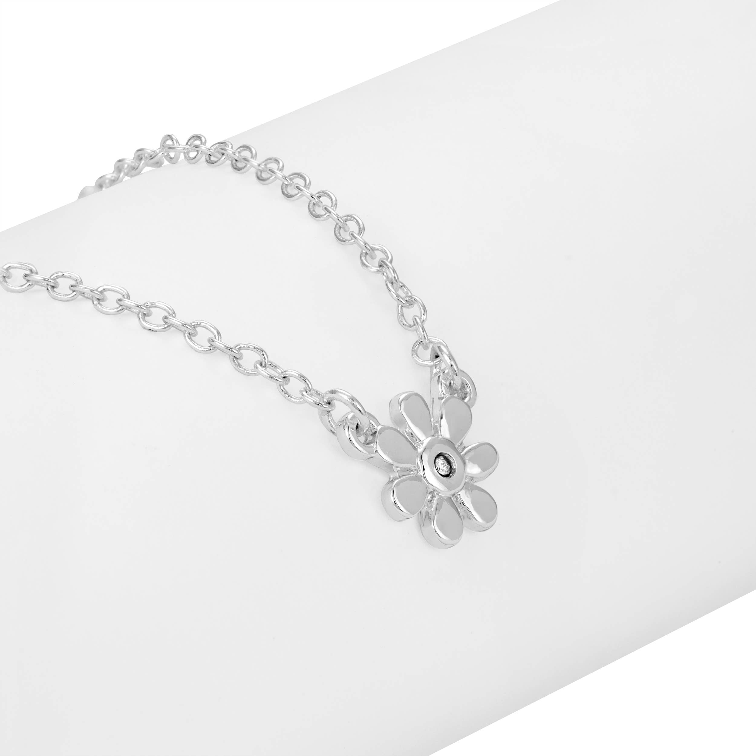Silver flower-shaped pendant on a chain against a white background