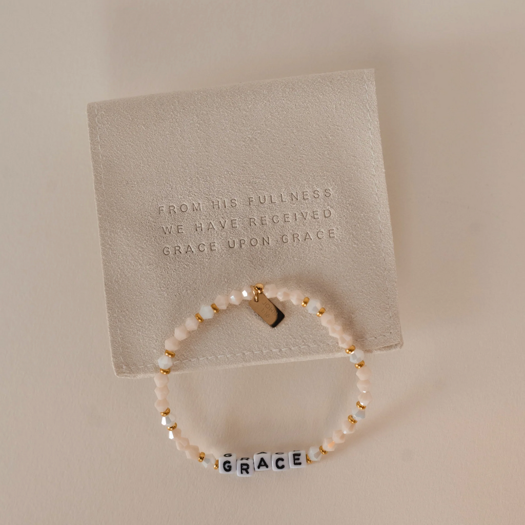 Bracelet with 'GRACE' on a card with text on a beige background