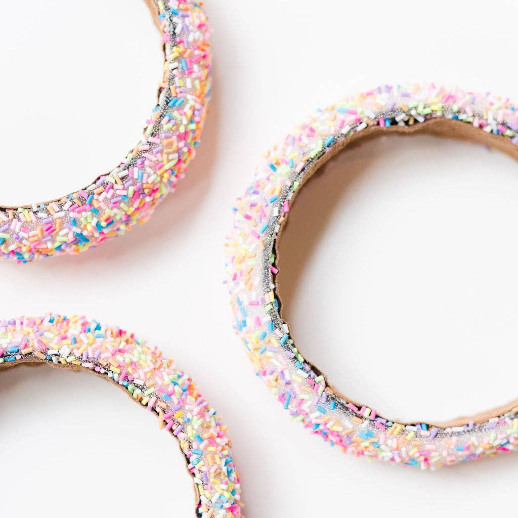 Three colorful headbands with sprinkles on a white background