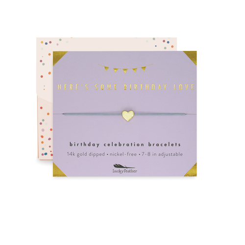 Bracelet packaging with gold heart charm on a white background