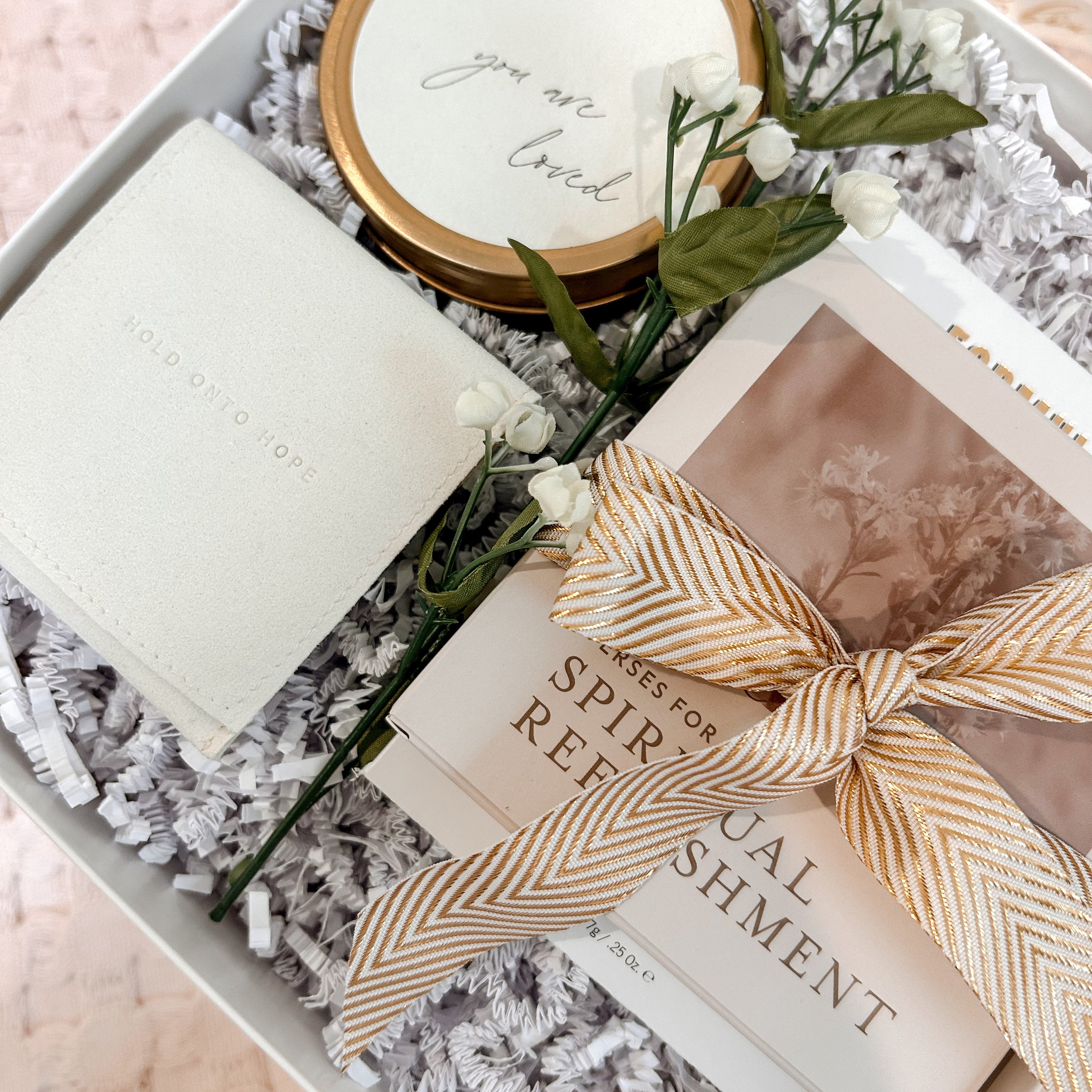 Gift set with candle, book, and decorative items in a box