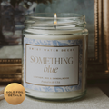 Candle in a glass jar with a decorative label on a textured surface