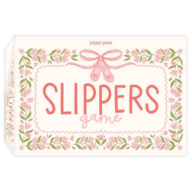 The product packaging for 'Slippers Game' by Pippi Post, featuring a cream-colored box decorated with pink floral borders, green leaves, and pink ballet slippers with a bow at the top.