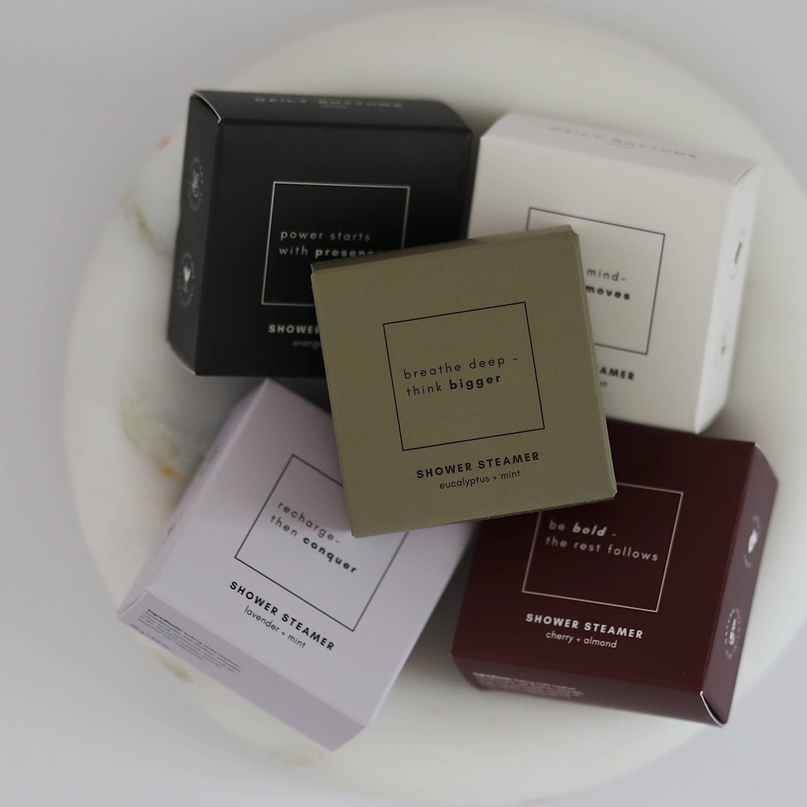 Collection of shower steamers with packaging on a white surface